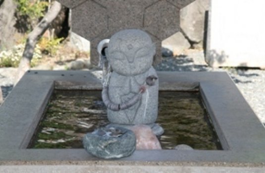 足湯の上にいる洗心お湯掛け地蔵が見守っています。奥では石和温泉すこやか観音が優しく見つめます。